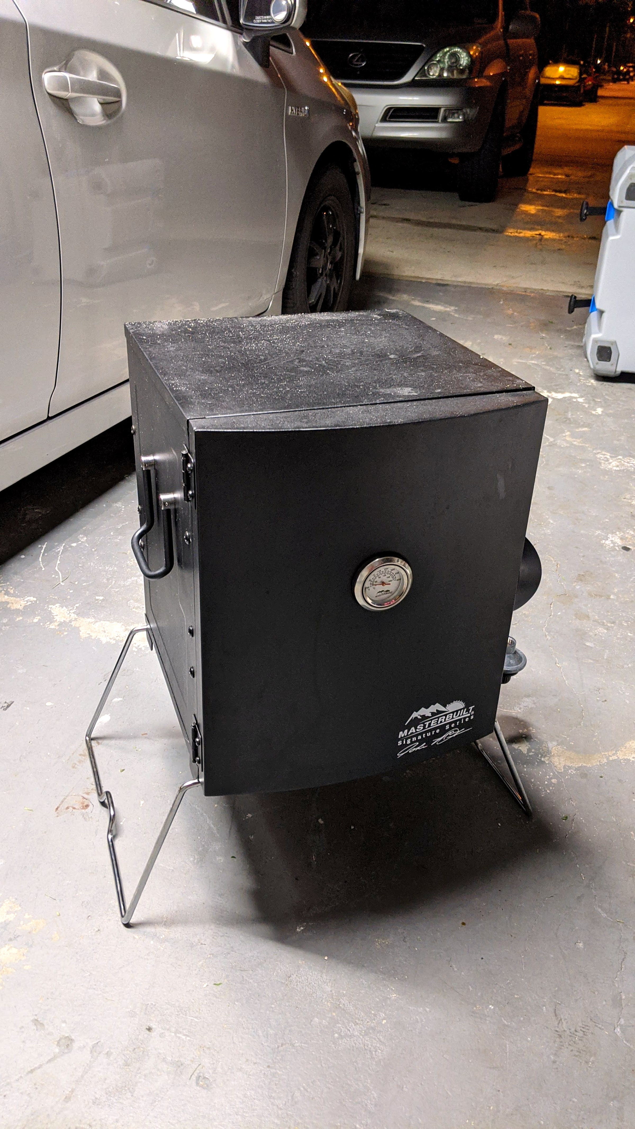 A close-up of the temperature gauge and vents on a portable Masterbuilt propane smoker