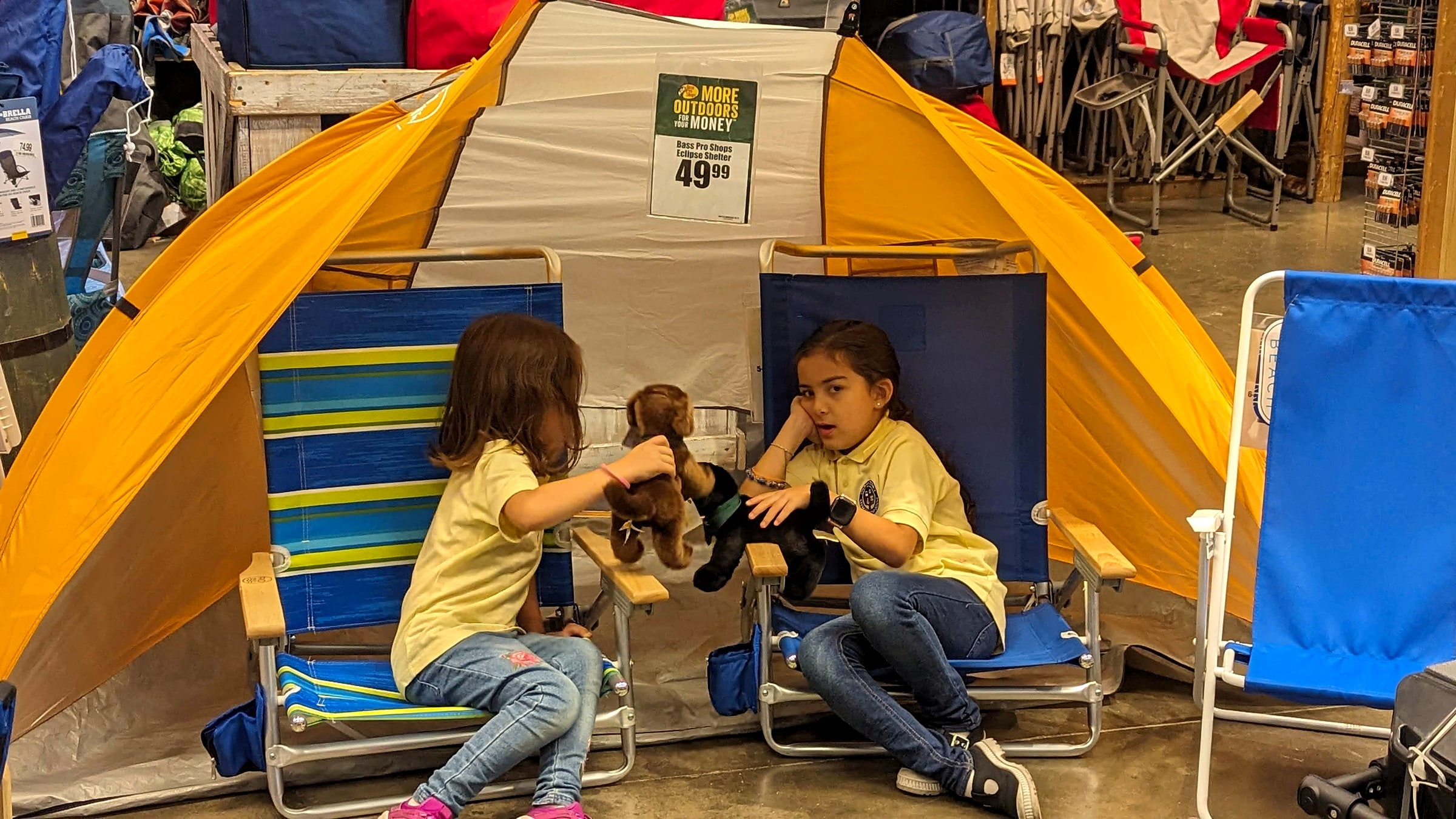 A young girl wearing a kid's smartwatch on her wrist while playing with a stuffed animal